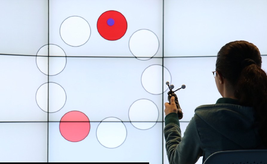 Study participant selecting targets on a large tiled wall display with a tracked pointing device
